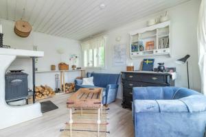 a living room with blue couches and a stove at VMA812-Kolsva-Lomstigen-7 in Kolsva