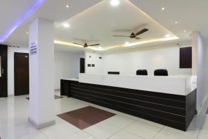a lobby with a reception desk with two ceiling fans at Collection O Mythri Hotel Near By ECIL, AS RAO Nagar, Sainikpuri in Hyderabad