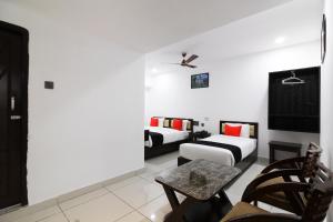 a living room with two beds and a table at Collection O Mythri Hotel Near By ECIL, AS RAO Nagar, Sainikpuri in Hyderabad