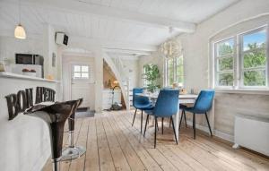 a dining room with a table and blue chairs at AE329-Aeroskobing-Oster-Bregninge-24 in Ærøskøbing