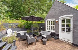 a patio with a table and chairs and an umbrella at AE329-Aeroskobing-Oster-Bregninge-24 in Ærøskøbing