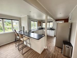 a kitchen with a counter and a refrigerator at Large Bach in Raglan central in Raglan