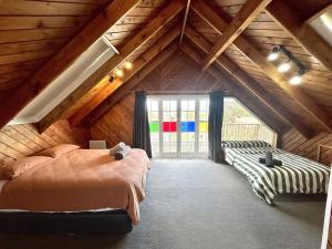 a bedroom with two beds in a attic at Large Bach in Raglan central in Raglan