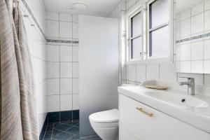 a white bathroom with a toilet and a sink at TV1729-Jerup-Engdraget-16 in Bratten Strand