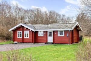 a small red house with a grass yard at TV1729-Jerup-Engdraget-16 in Bratten Strand