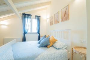 a bedroom with a bed with blue and yellow pillows at Ulivo, Relax a due passi dal mare in San Lazzaro +25 photos