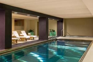 a swimming pool in a hotel lobby with chairs at The Westin Minneapolis in Minneapolis