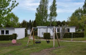 a swing set in a yard with a house at Gorgeous Home In Ystad in Ystad +20 photos