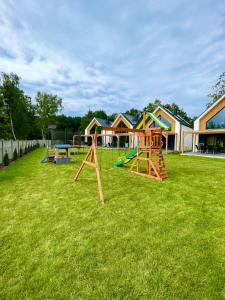 a yard with a playground with play equipment in it at Mare Boutique Houses in Niechorze