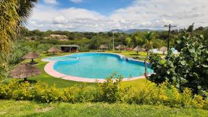 a large swimming pool in a yard with grass at Cabaña Oasis Ixmiquilpan in Ixmiquilpan