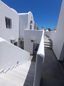 a stairway with white stairs on a white building at Perissa Economy Rooms in Santorini
