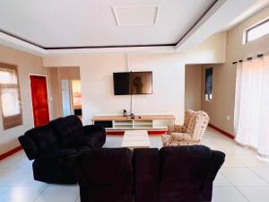 a living room with two couches and a tv at Lamamie Lodge in Thohoyandou