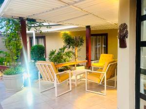 a patio with chairs and a table and a table and chairs at Lamamie Lodge in Thohoyandou