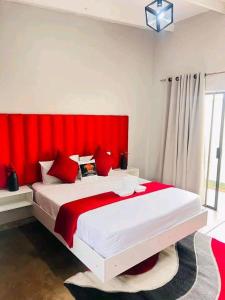 a bedroom with a large bed with a red headboard at Lamamie Lodge in Thohoyandou +21 photos