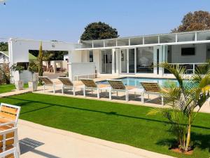 a house with a swimming pool and lawn at Lamamie Lodge in Thohoyandou