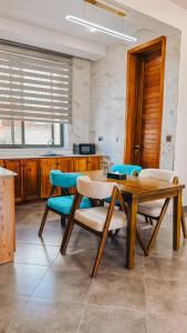 a dining room with a wooden table and chairs at Zabibu Collection in Arusha