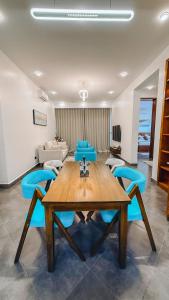 a dining room with a wooden table and blue chairs at Zabibu Collection in Arusha