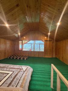 a large room with two beds in a wooden room at the jibhi nest cottage in Mandi