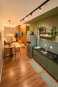 a kitchen with a refrigerator and a table and a living room at Apartamento Premium Centro 103 in Foz do Iguaçu