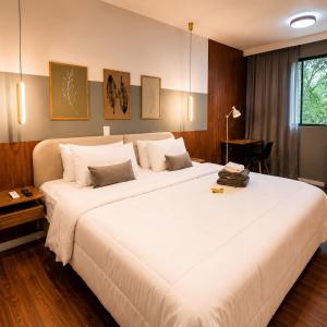 a large white bed in a hotel room at Apartamento Premium Centro 103 in Foz do Iguaçu