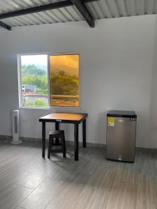 a table in a room with a window and a trash can at Ambar Apartahotel - Clasico in San Luis
