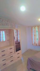a bedroom with a large wooden dresser in a room at Nasau Holiday Apartment in Sigatoka
