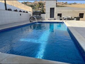 a swimming pool with blue water in a building at Casablanca chalet in Umm Nūwārah