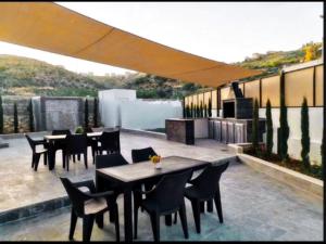 a patio with tables and chairs on a roof at Casablanca chalet in Umm Nūwārah