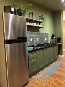 a kitchen with a stainless steel refrigerator and green cabinets at Apartamento Premium Centro 103 in Foz do Iguaçu +18 photos