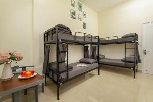 two bunk beds in a room with a table at Queen Cafe Hostel in Hanoi