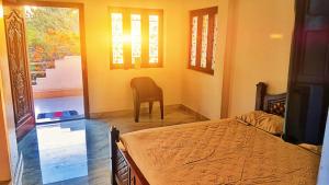 a bedroom with a bed and a chair in a room at Sri Ram Villa in Rāmeswaram