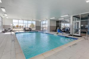 a large pool with blue water in a building at Comfort Suites Waco North - Near University Area in Waco