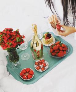 a tray with a plate of strawberries and a bottle of champagne at Alaçatı The Design Hotel in Alacati