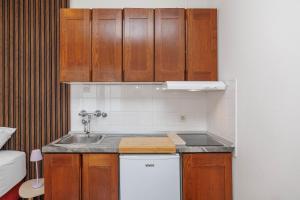 a small kitchen with wooden cabinets and a sink at Maja Apartments Malinska in Malinska +169 photos