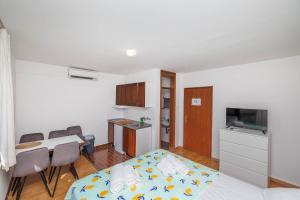 a small room with a bed and a table and a kitchen at Maja Apartments Malinska in Malinska