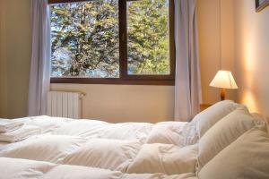 a white bed in a room with a window at Rancho del Lago in San Carlos de Bariloche