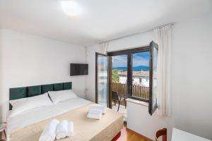 a bedroom with a bed and a large window at Maja Apartments Malinska in Malinska