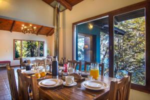 a dining room with a wooden table and a large window at Rancho del Lago in San Carlos de Bariloche