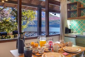 a table with food and a view of a lake at Rancho del Lago in San Carlos de Bariloche +65 photos
