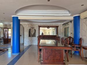 a dining room with a table and blue columns at Coastal Comforts at Casabianca in Dawwār Muḩammad Abū Shanab