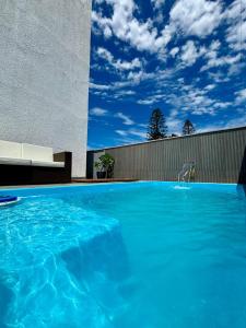 a large swimming pool with blue water in front of a building at Pousada 8 Mares in Arraial do Cabo