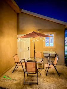 a patio with a table and chairs and an umbrella at Phoenix Eden in Portmore
