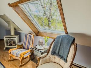a living room with a skylight and two chairs at The Governor's Inn in Ludlow