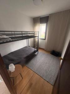 a bedroom with a bunk bed and a table and a window at Casa do camiño in Villariño