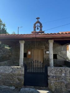 a stone house with a gate and a cross on top at Casa do camiño in Villariño
