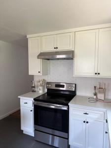 a kitchen with white cabinets and a stove top oven at Boho room in house in New Haven
