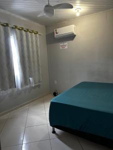 a bedroom with a bed and a window and a fan at Casa temporada Guarapari in Guarapari +27 photos