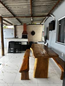 a wooden bench in a living room with a piano at Casa temporada Guarapari in Guarapari