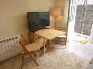 a living room with a table with a television on it at Eastern Lodge 11B in Lymington +5 photos
