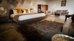 a bedroom with a large bed and a living room at Casa Diamante Viñedos in Ezequiel Montes